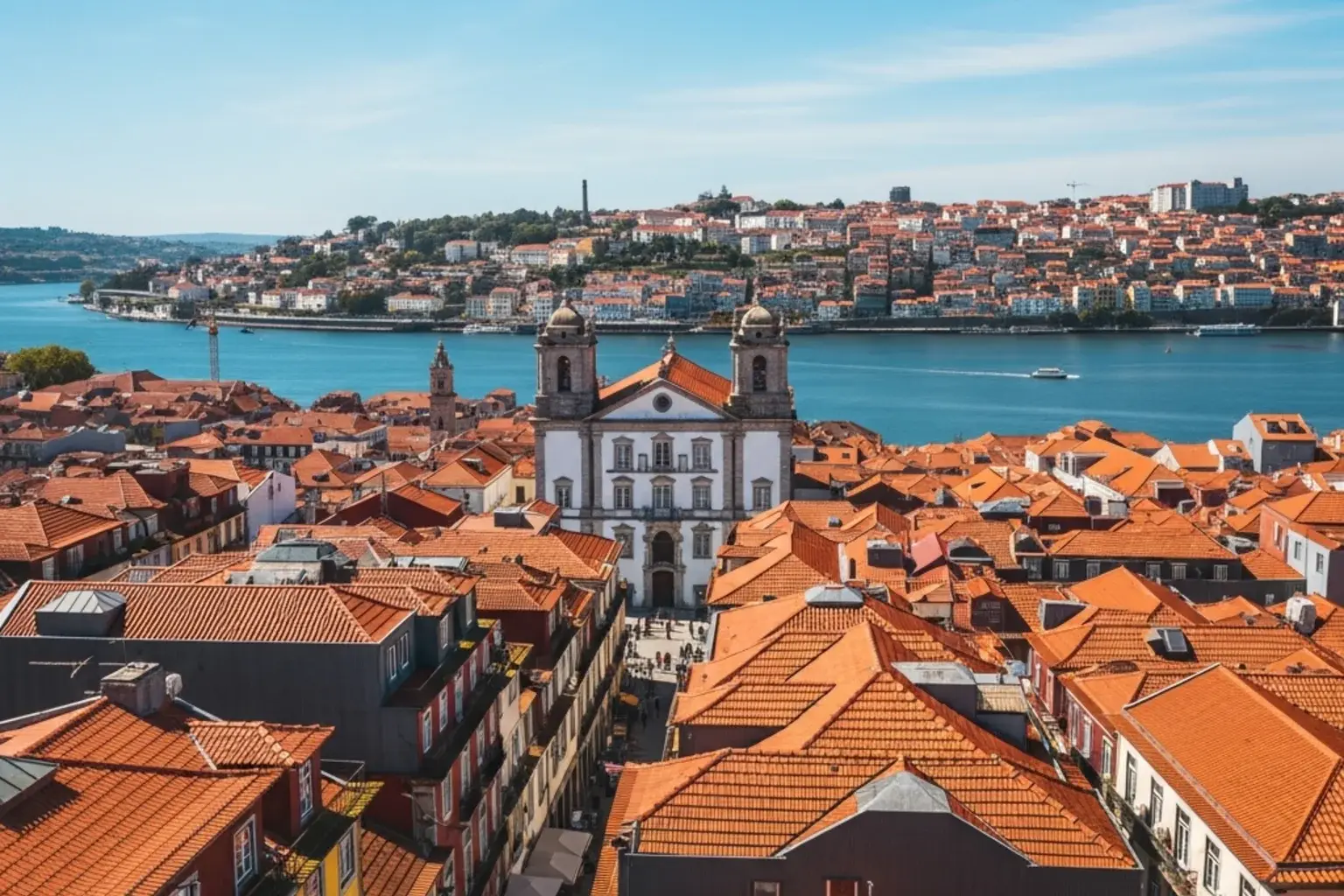 Vista aerea de uma cidade portuguesa com telhados laranjas e rio ao fundo